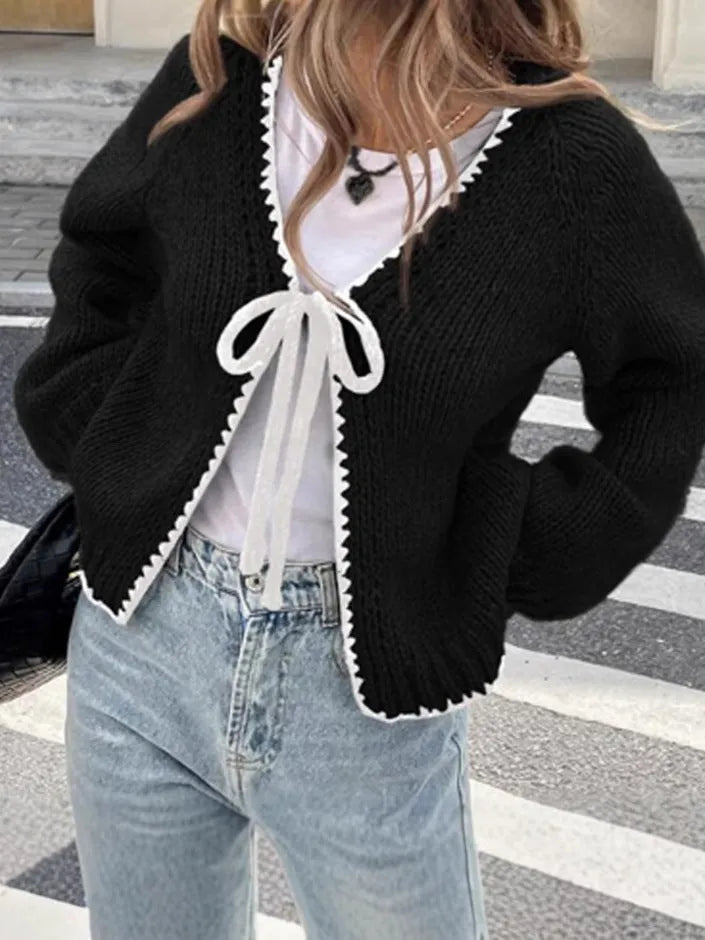 Grey lace-up front cardigan sweater with long sleeves and a crocheted flower detail.