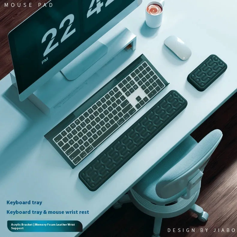 Double-sided black and grey keyboard mouse pad with wrist strap and hand pillow on a desk.