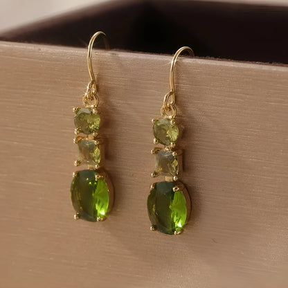 A pair of green geometric quadrilateral-shaped copper earrings with a retro bohemian style.