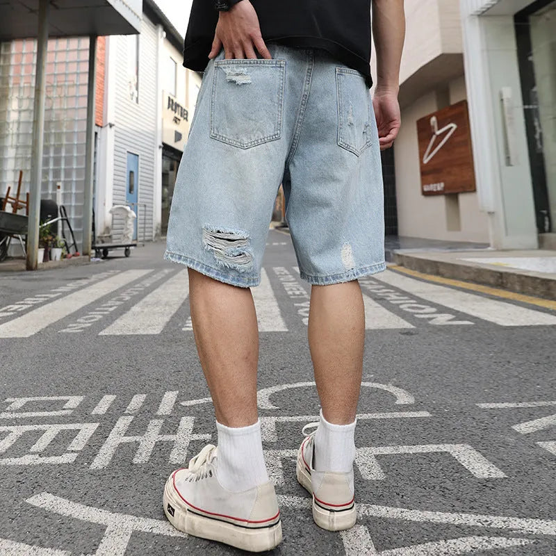 Light blue distressed denim shorts with rips and loose straight fit on mannequin