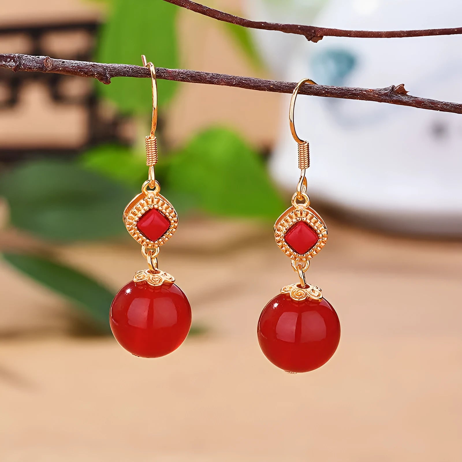 Geometric silver-toned earrings with round red agate beads and small inlaid jasper stone accents.