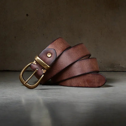 Men's black cattlehide leather jeans belt with a copper pin buckle shown on a flat surface.