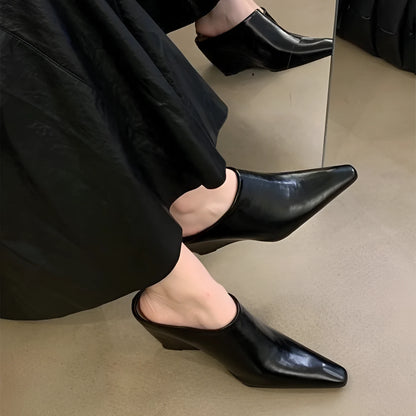 Women's black wind wedge closed toe half slippers showing PU upper and open back.
