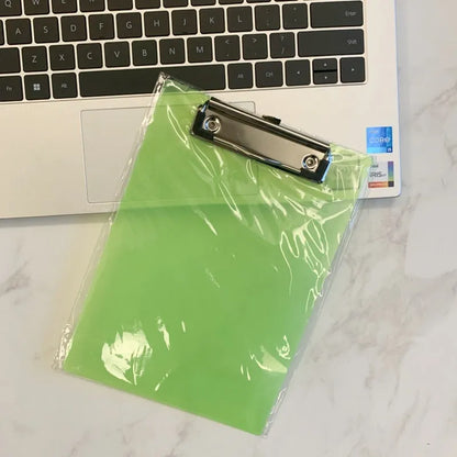 Transparent A4 plastic plate holder with metal clip, holding white paper, on a desk.