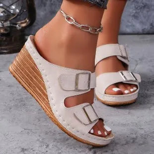 Women's creamy-white outer wedge beach slippers with a belt buckle detail on the strap.