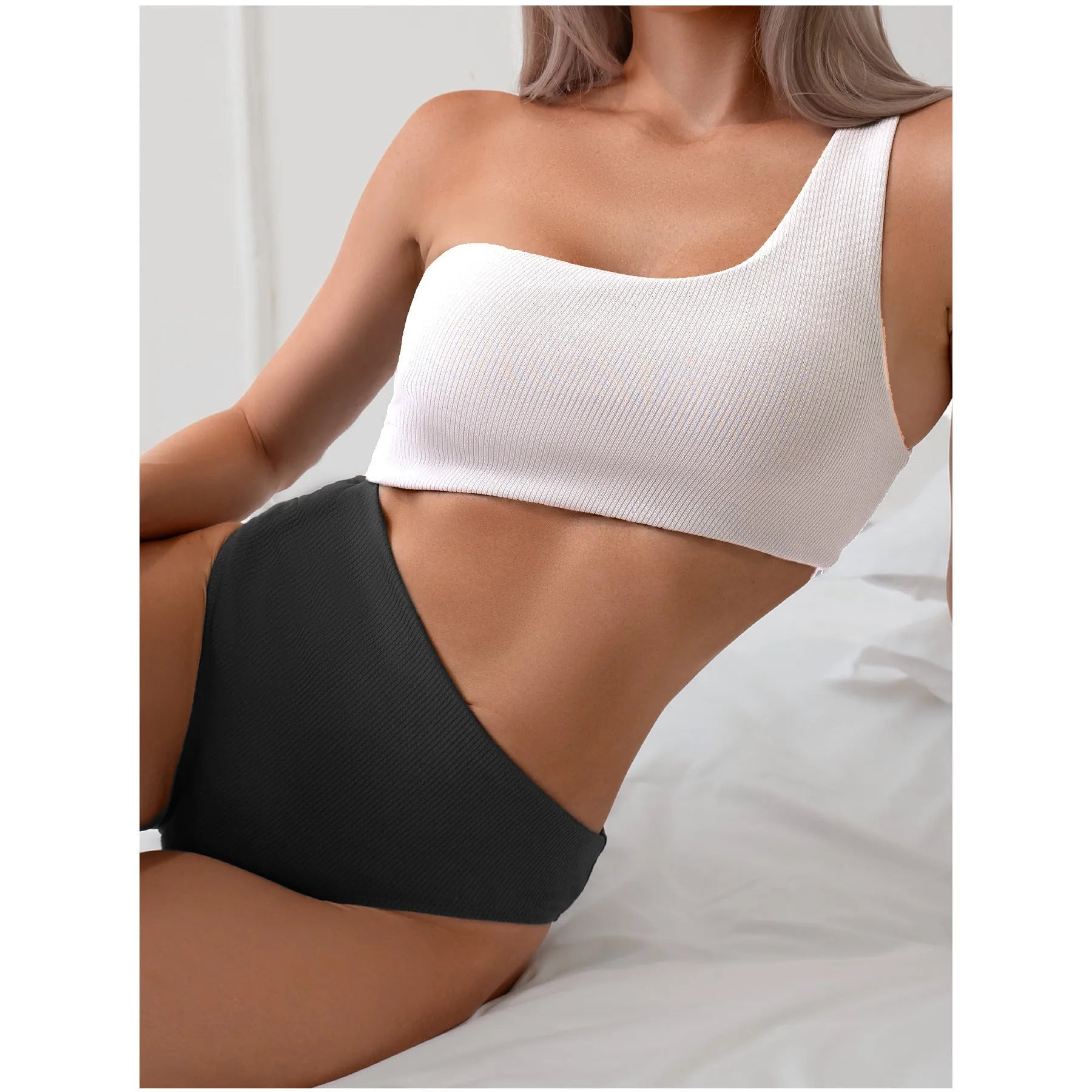 Light grey one-shoulder one-piece swimsuit on a mannequin, showing the single strap and solid colour design.
