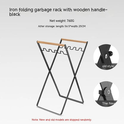 Black outdoor folding trash rack with wooden handle, holding a waste bag.