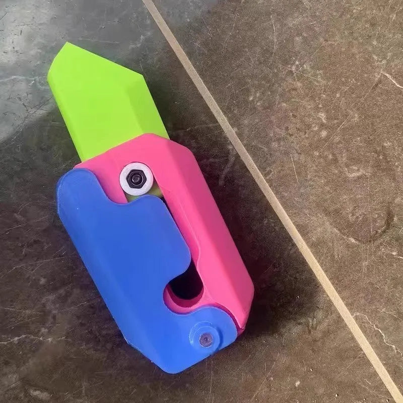 3D printed plastic carrot fidget knife with retractable blade, shown in orange and green colour scheme.