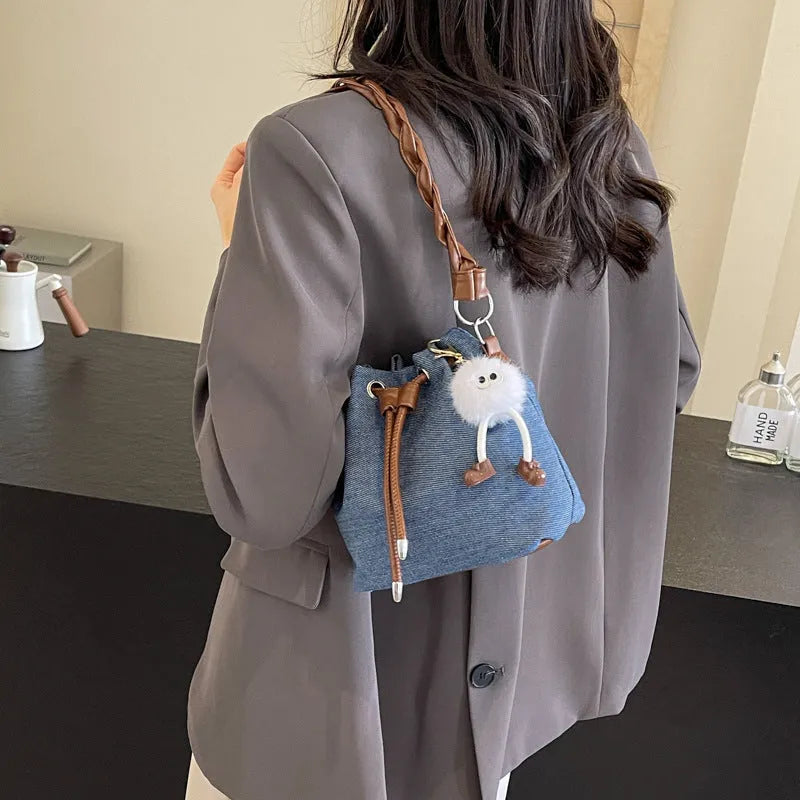 Blue cross body bucket bag with synthetic leather lining and adjustable shoulder strap