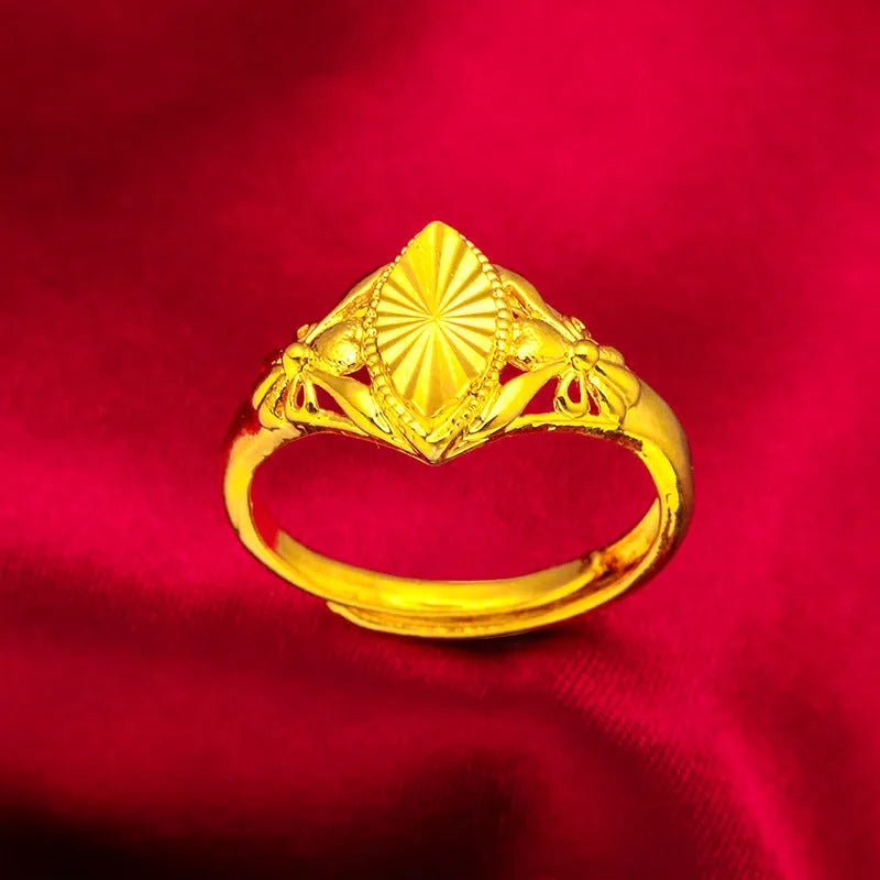 Geometric gold brass ring with open floral cut-out design and textured band, shown from the side.
