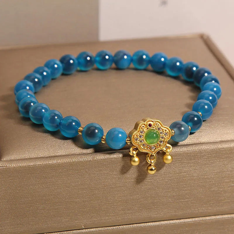 Blue sugar heart agate safety lock pendant on a women's crystal bracelet with alloy inlay and rhinestones.