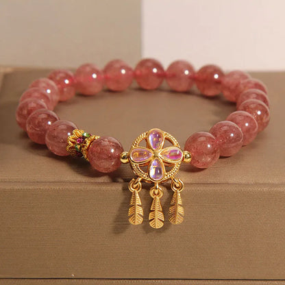 Women's strawberry quartz crystal bracelet with a four-leaf clover dream catcher pendant.