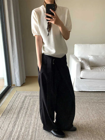 Black straight-leg trousers with single front pleat and adjustable waistband on a hanger