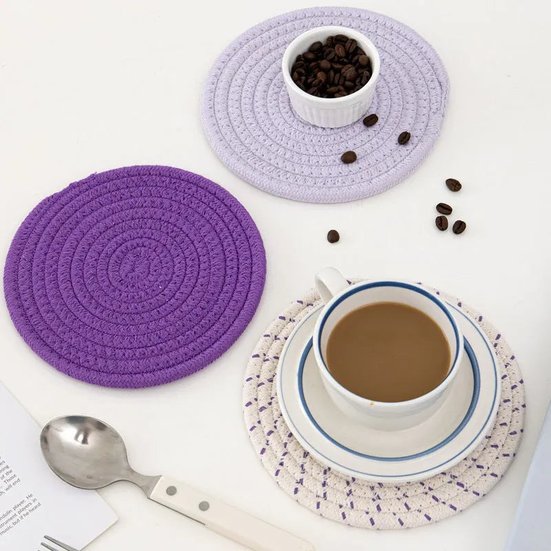 Three round grey cotton cord coaster placemats on a wooden table, each 18cm in diameter.