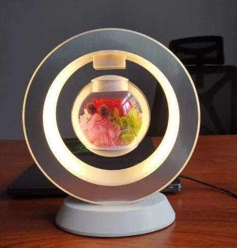 Pink rose eternal flower floating in magnetic levitation LED night light with triangular base and touch control