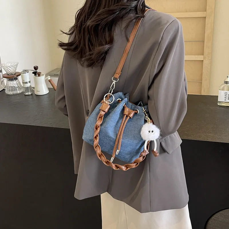 Blue cross body bucket bag with synthetic leather lining and adjustable shoulder strap