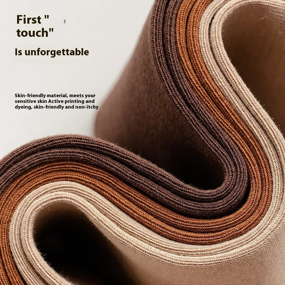 Pair of solid-colour men's mid-calf socks made from combed cotton on a wooden background