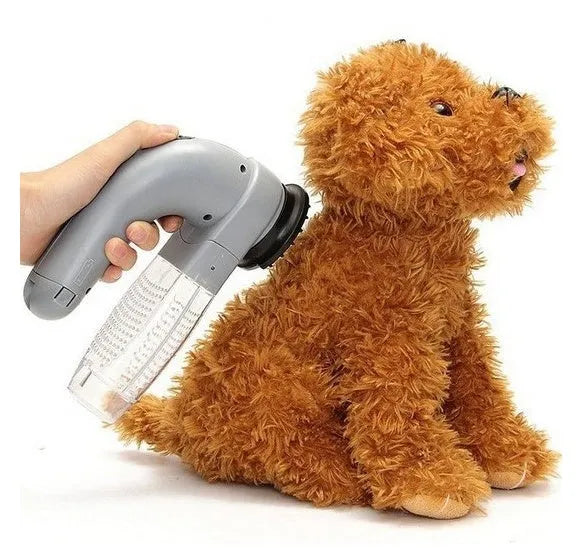 Grey handheld electric pet hair remover brush with soft rubber head for grooming dogs and cats.