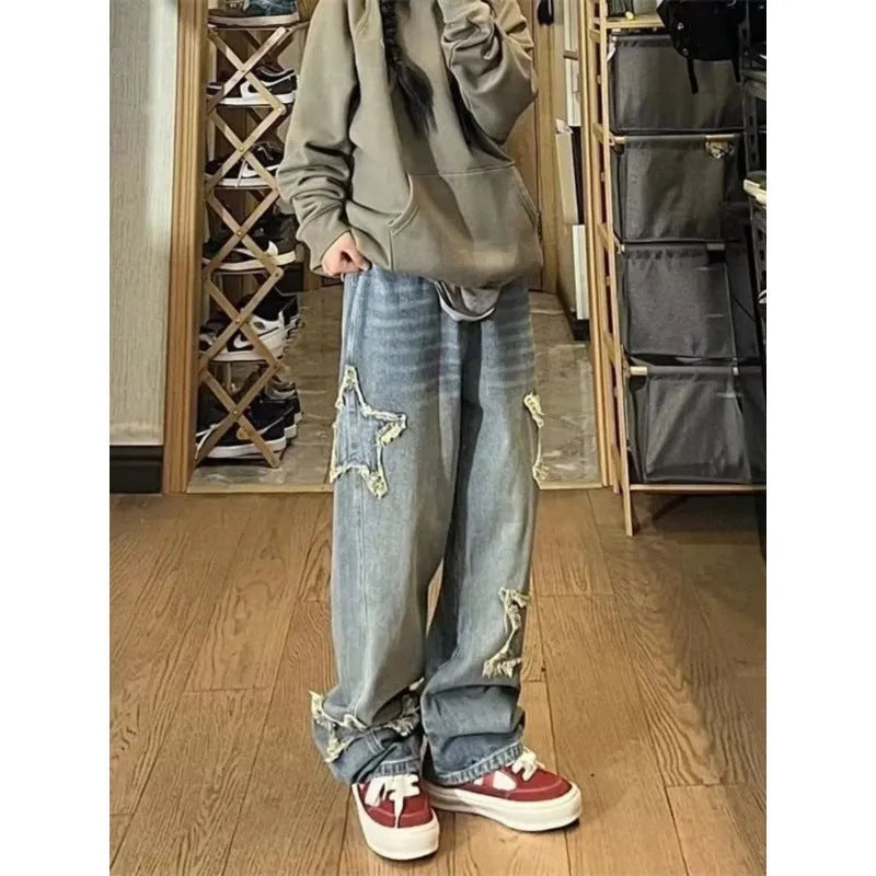 Blue high-waisted wide-leg denim trousers with a straight-leg cut on a model.