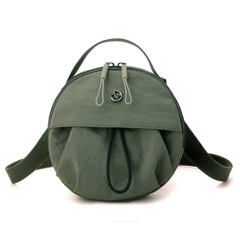 Out shoulder crossbody messenger bag in nylon showing interior zipped changing bag, phone pocket, and document compartment.