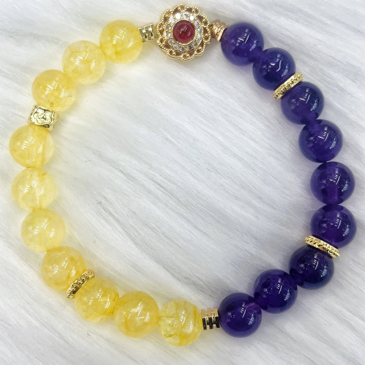Handmade women's bracelet with yellow and purple amethyst crystals on wrist.