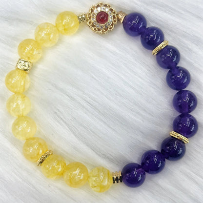 Handmade women's bracelet with yellow and purple amethyst crystals on wrist.
