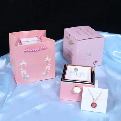 Rotating rose jewellery gift box with a preserved red rose under a clear acrylic dome, showing the interior rotating drawer.