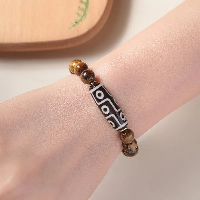 Buddha bead bracelet unisex spiritual jewellery featuring a single tigereye dzi bead centrepiece with 6mm, 8mm, 10mm or 12mm specification and adjustable closure for ethnic style and simplicity.