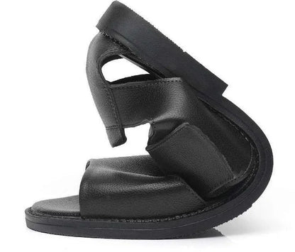 Men's brown leather Roman sandals with an open toe and rubber sole on a wooden surface.