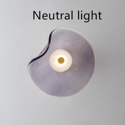 Round glass wall lamp mounted beside bed in cognac colour with 220V operation for bedside lighting