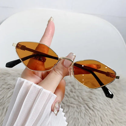 Gold metal frame rhombus-shaped cat eye sunglasses on a neutral background.