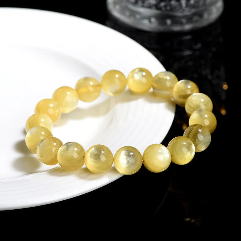 Yellow golden dragon mica round beads bracelet with polished geometric beads on a string.
