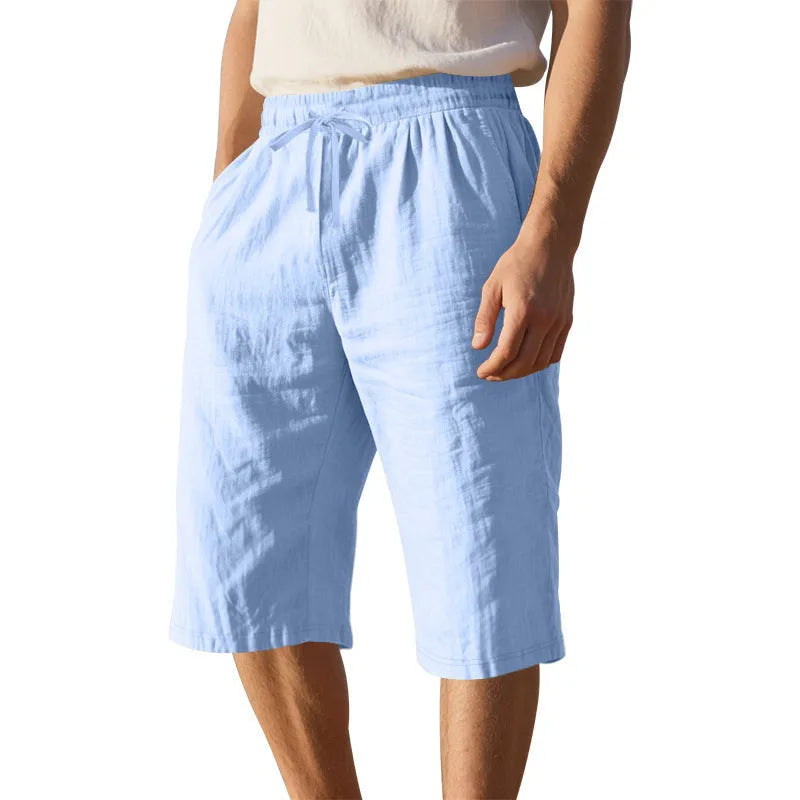 Men's loose-fit linen shorts in a solid colour with a drawstring waist and cropped leg length.
