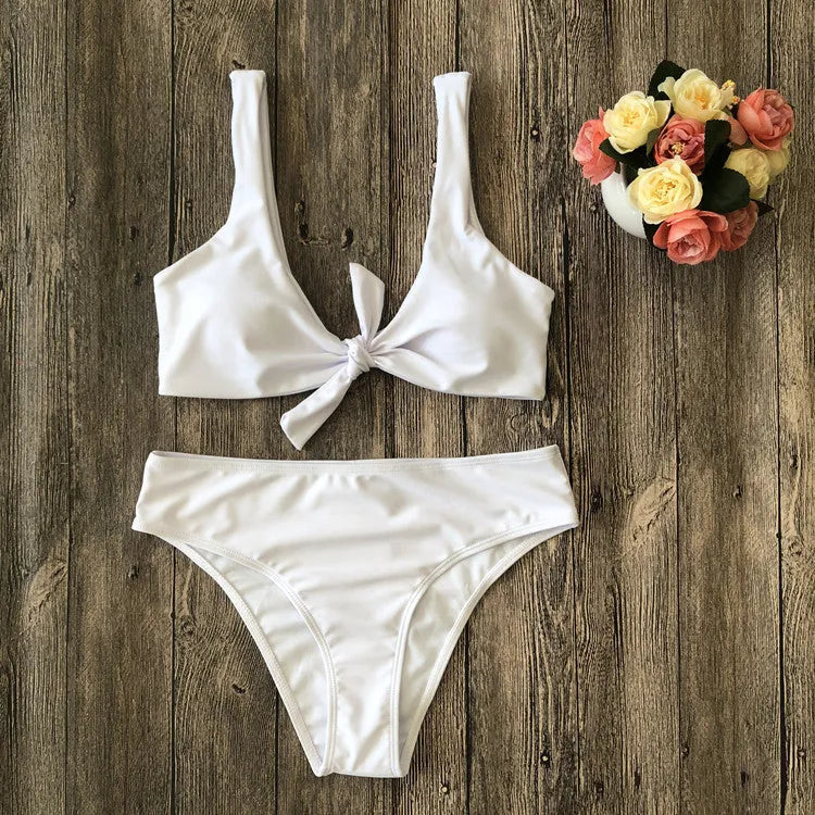 Women's solid colour bikini set with sleeveless top and briefs on a neutral background