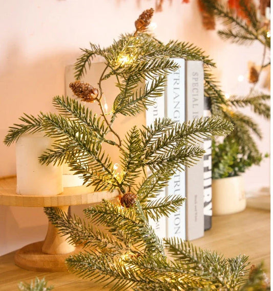 Decorative copper leaf string lights with rattan and pine needle accents, creating a cozy, festive atmosphere