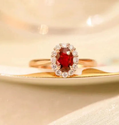 Gold pigeon and floral design women's ring with red gemstone inlay on a silver band.
