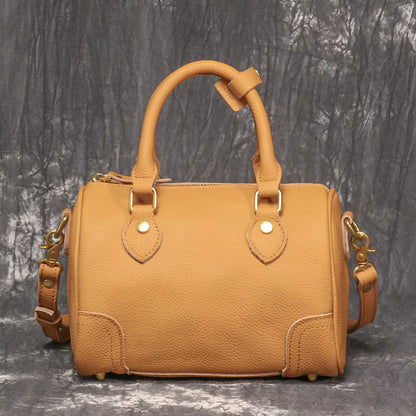 Handmade cylindrical brown Boston bag made from first layer cowhide leather with a single shoulder strap.