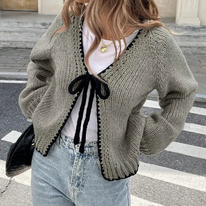 Grey lace-up front cardigan sweater with long sleeves and a crocheted flower detail.