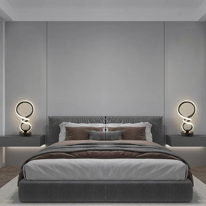 Black remote-controlled LED night light with Bluetooth remote on a bedside table.