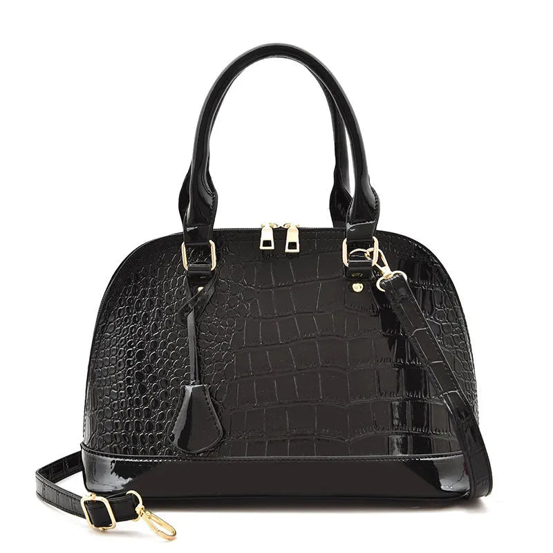 Large shiny black PU leather crossbody bag with a shell shape, shown from the front.