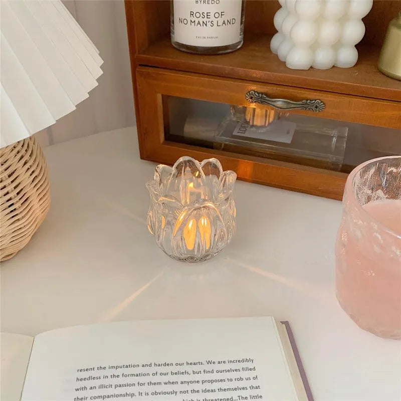 Transparent glass tulip candle holder with classic tumbler base on table