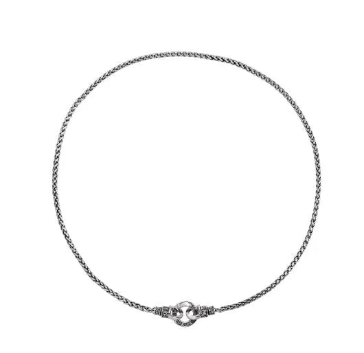 A simple sterling silver clavicle necklace with a small pendant, shown on a model.