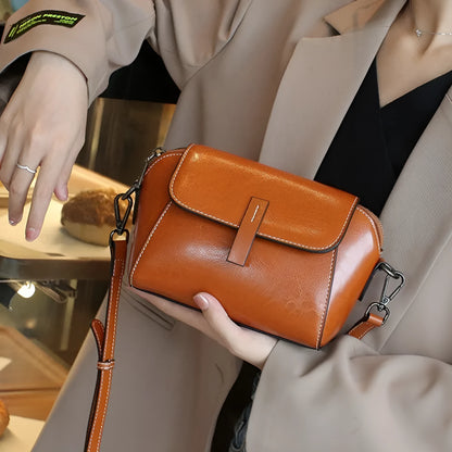 Women's brown oil wax cowhide leather messenger bag with crossbody strap and organised interior pockets