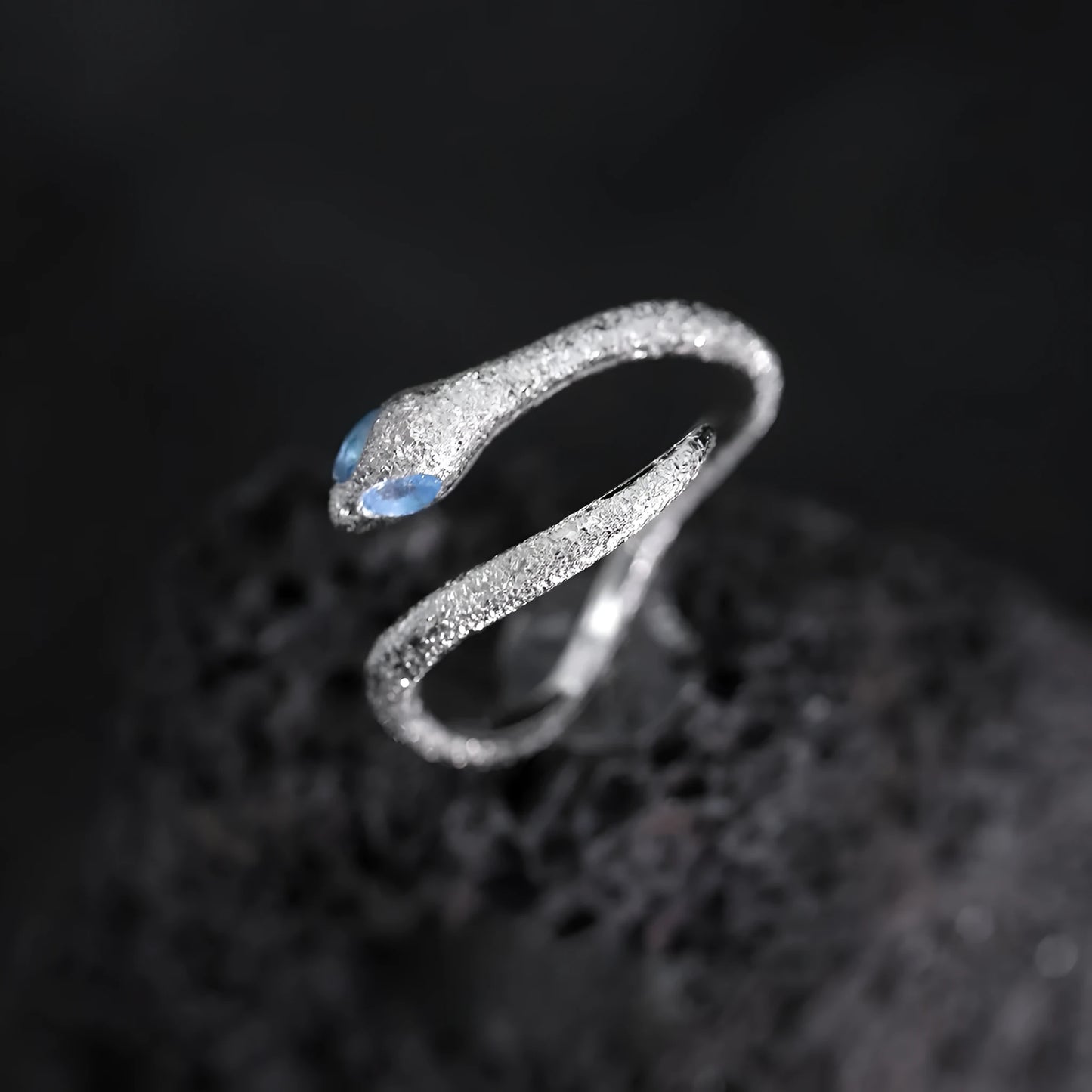 Platinum colour adjustable snake design ring for women on a neutral background.