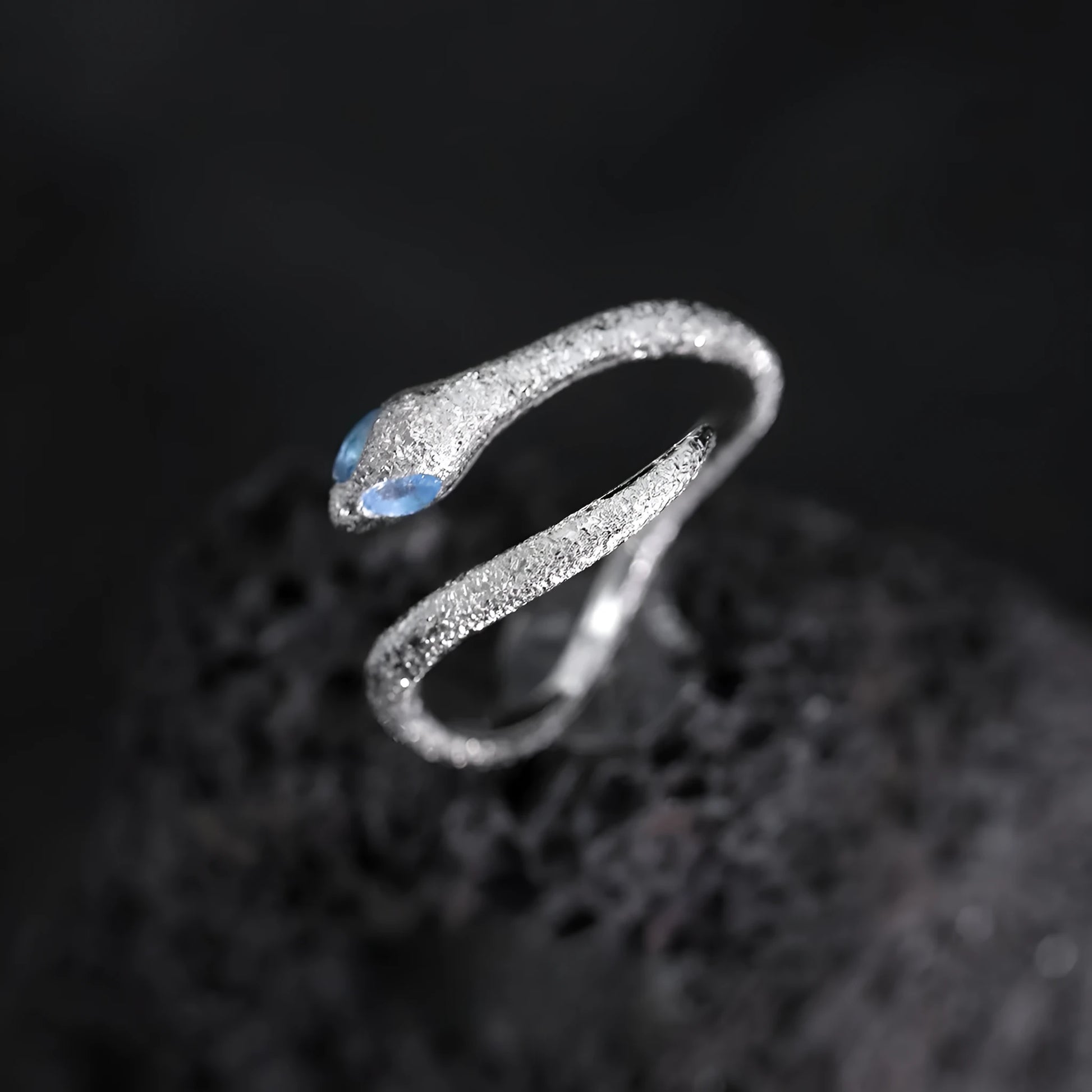 Platinum colour adjustable snake design ring for women on a neutral background.