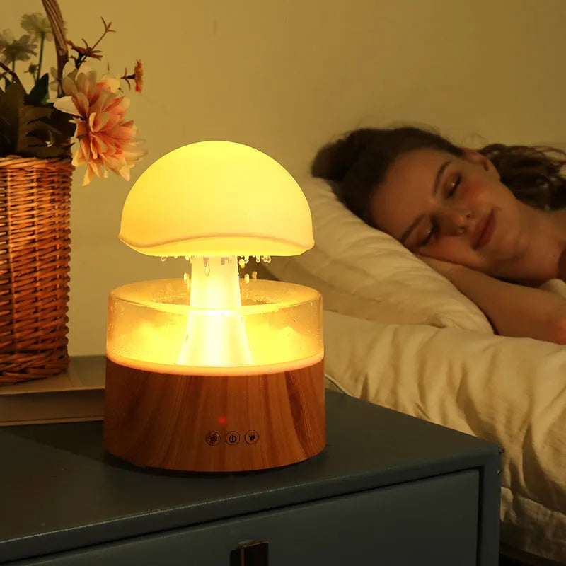 White cloud-shaped humidifier emitting mist with multicoloured LED light and water droplets