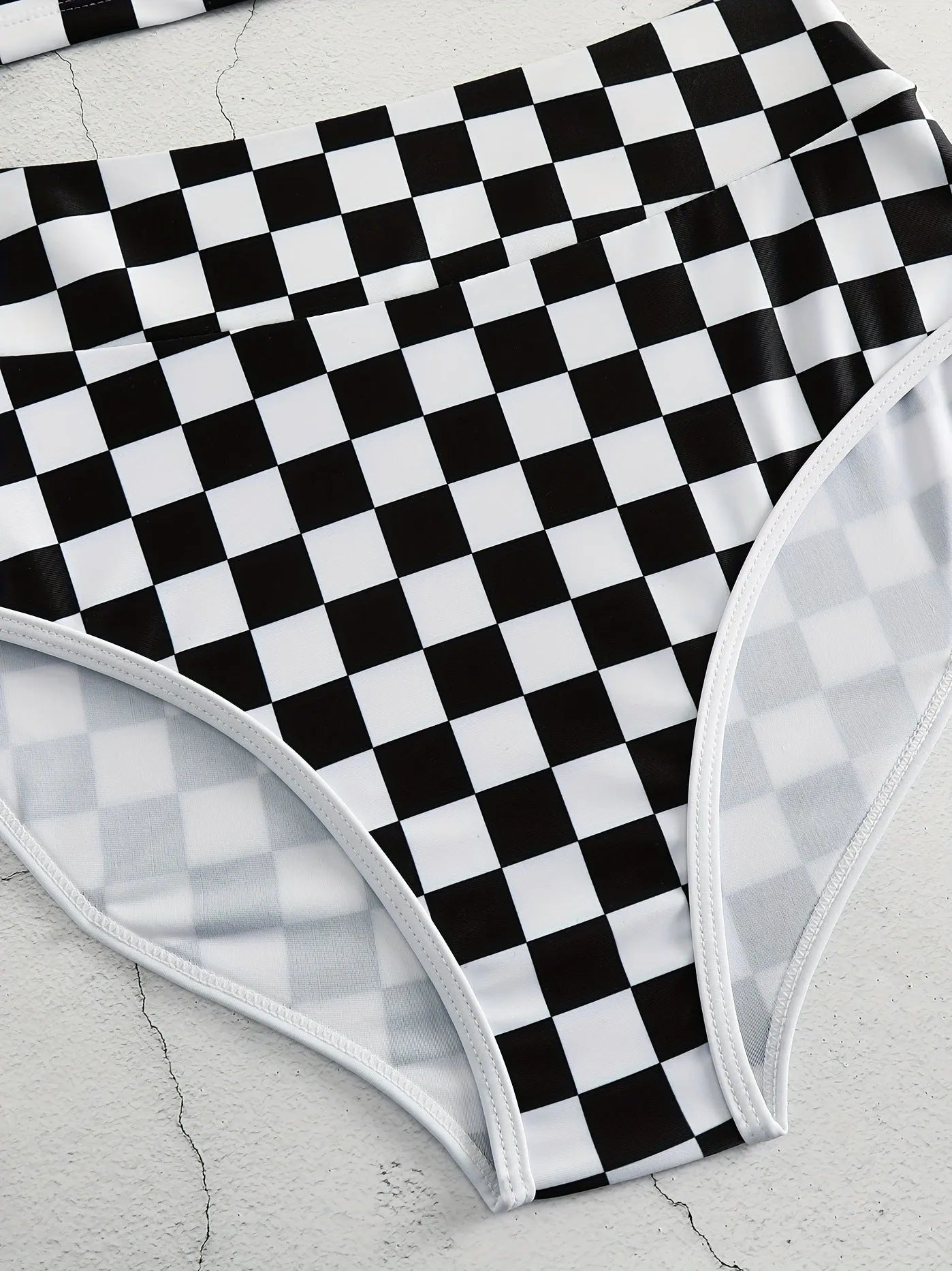 Women's checkerboard print backless one-piece swimsuit with suspender straps for swimming.