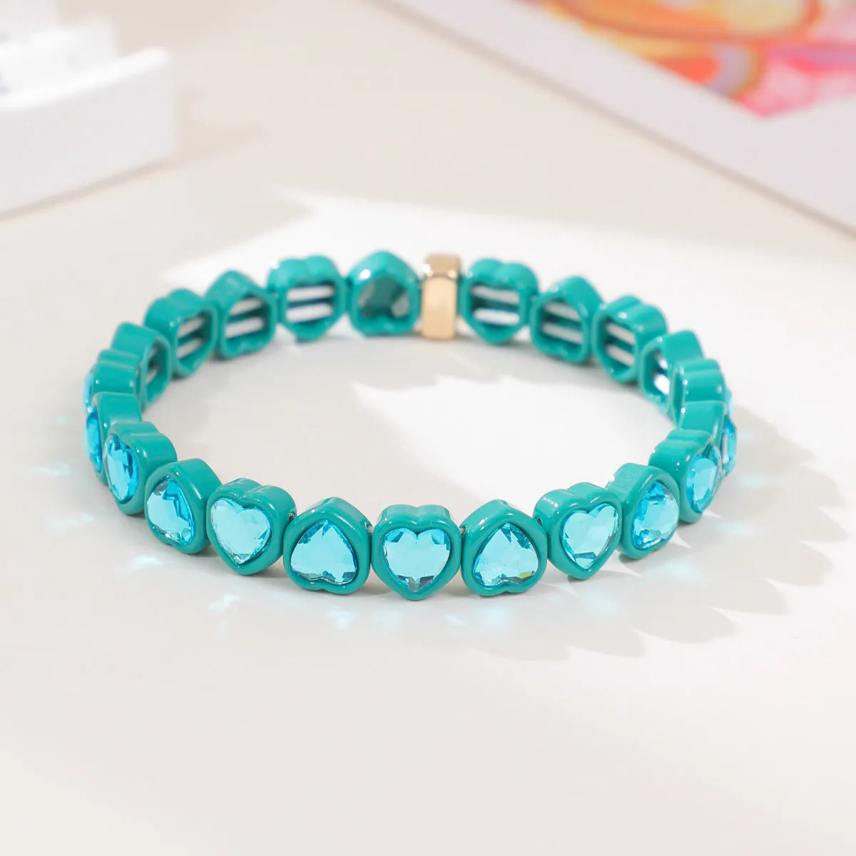 Colourful enamel heart shape on a silver-toned alloy stretch bracelet.