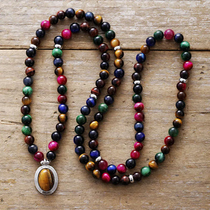 Coloured tiger-eye natural stone bead necklace and bracelet set with 108 gem-inlaid pendants on a dark background.