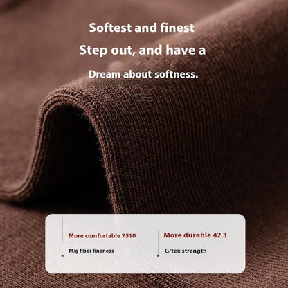 Pair of solid-colour men's mid-calf socks made from combed cotton on a wooden background